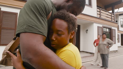 Niño-Abrazando-A-Su-Padre-Militar-Y-Despidiéndose-De-él-Mientras-En-La-Distancia-Su-Madre-Y-Abuela-Los-Miraban