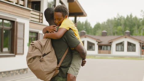 Back-View-Of-An-Military-Father-Holding-And-Embracing-His-Son-Outside-Home