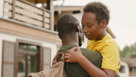 Back-View-Of-An-Military-Father-Holding-And-Embracing-His-Son-Outside-Home-1