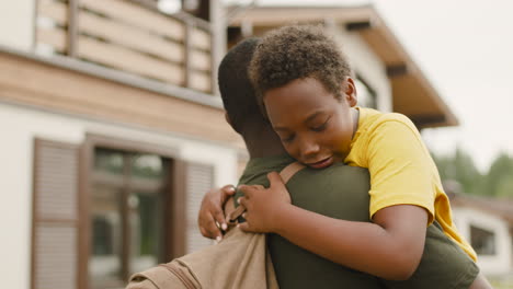 Military-Father-Holding-And-Embracing-His-Sad-Son-Outside-Home