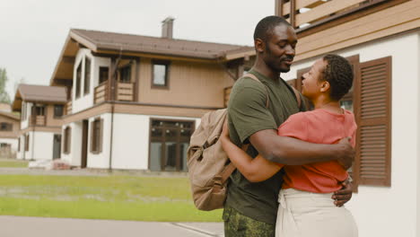 Loving-Couple-Embracing-Outside-Home-Before-Man-Going-To-Military-Service