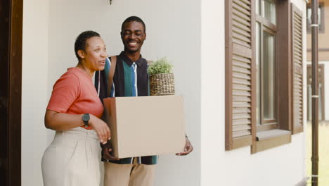 Young-Man-Holding-Box-And-Talking-With-His-Mom-Before-Moving-Home