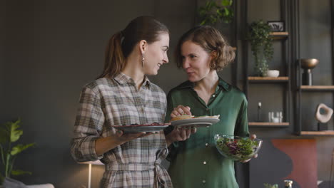 Two-Happy-Women-Talking-About-Food-And-Laughing-Together-At-Home