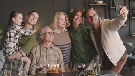 Feliz-Anciano-Y-Su-Familia-Multigeneracional-Tomando-Una-Foto-Selfie-Durante-Su-Fiesta-De-Cumpleaños-En-Casa