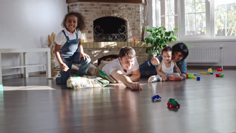 Happy-Married-Couple-Play-With-Their-Son-With-Toys-On-The-Floor-In-Living-Room