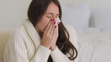 Kranke-Frau-Mit-Atemwegserkrankungen,-Die-Ihre-Nase-In-Ein-Taschentuch-Bläst,-Das-Zu-Hause-Im-Schlafzimmer-Sitzt