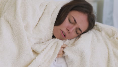 Sick-Woman-Coughing-Lying-On-The-Bed-Wrapped-In-A-White-Blanket