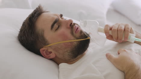 Sick-Man-Lying-On-Bed-Taking-His-Oxygen-Mask-Off-And-Coughing