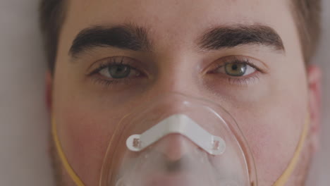 Close-Up-Of-A-Sick-Man-Breathing-Through-Oxygen-Mask-And-Looking-At-Camera-1