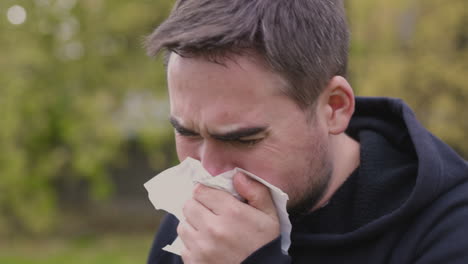 Sick-Man-At-Park-Coughing-In-A-Handkerchief