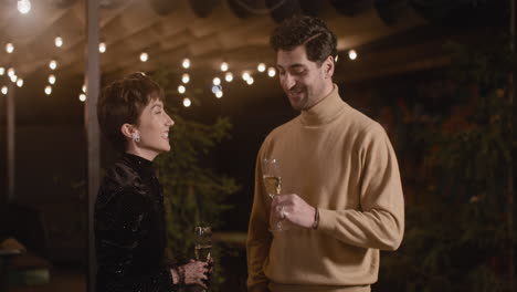 Elegant-Woman-And-Handsome-Man-Talking-And-Drinking-Champagne-At-New-Year's-Eve-Party