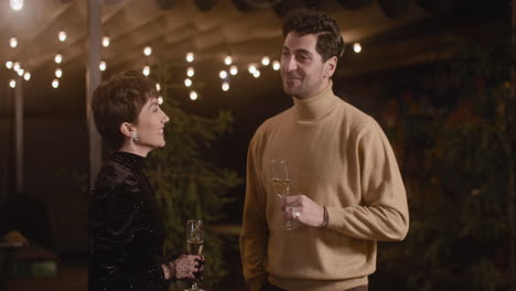 Elegant-Woman-And-Handsome-Man-Talking-And-Laughing-Together-At-New-Year's-Eve-Party