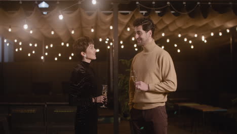 Elegant-Woman-And-Handsome-Man-Talking-And-Drinking-Champagne-At-New-Year's-Eve-Party-1