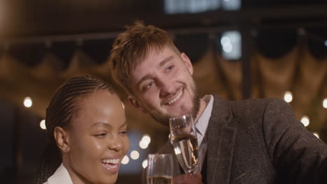 Portrait-Of-A-Man-And-Woman-Toasting-With-Champagne-Glasses-While-Taking-A-Selfie-Video-At-New-Year's-Eve-Party