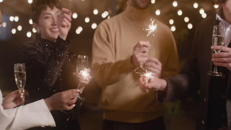 Group-Of-Four-Multiethnic-Friends-With-Champagne-Glasses-Having-Fun-With-Sparklers-At-New-Year's-Eve-Party-1