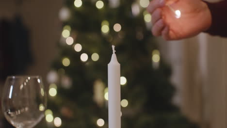 Camera-Focuses-On-Man's-Hands-Lighting-A-Candle-For-Christmas-Dinner