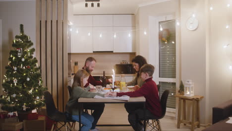 Couple-And-Their-Children-Pray-And-Bless-The-Table-Before-Christmas-Family-Dinner-1