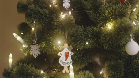Die-Kamera-Konzentriert-Sich-Auf-Den-Engel,-Der-Mit-Lichtern-Am-Weihnachtsbaum-Hängt