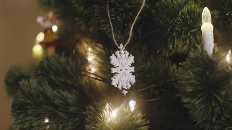 Camera-Focuses-On-Snowflake-Hanging-On-Christmas-Tree-With-Lights