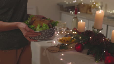 Unrecognizable-Woman-Putting-Roast-Chicken-On-Christmas-Dinner-Table