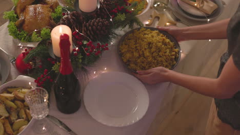 Mujer-Irreconocible-Poniendo-Delicioso-Arroz-En-La-Mesa-De-La-Cena-De-Navidad