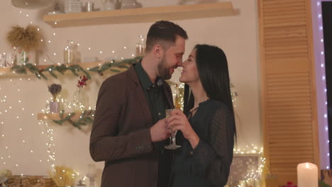 Loving-Couple-Toasting-And-Giving-Eskimo-Kiss-At-Home-During-Christmas-Dinner