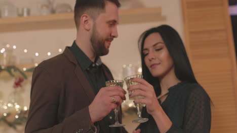 Loving-Couple-Toasting-And-Looking-To-Each-Other-At-Home-On-Christmas
