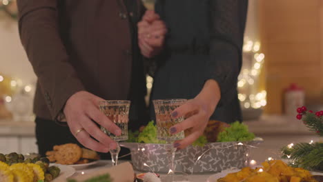 Liebespaar-Nimmt-Champagnergläser-Vom-Tisch-Und-Stößt-An-Weihnachten-Zu-Hause-An