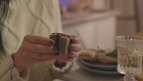 Surprised-Woman-Opening-Engagement-Ring-Box-During-Christmas-Dinner-At-Home