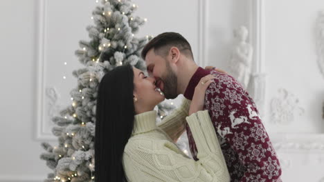 Loving-Couple-Hugging-And-Kissing-On-Christmas-At-Home