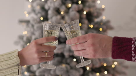 Close-Up-Of-An-Unrecognozable-Couple-Toasting-With-Chamapgne-Glasses-On-Christmas