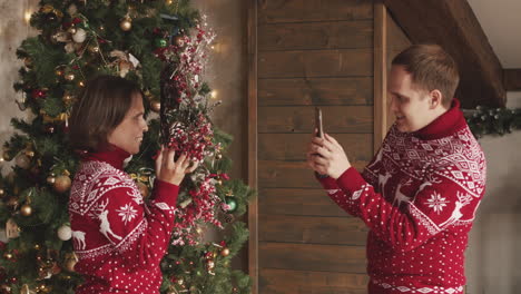 Man-Taking-A-Funny-Video-Of-His-Wife-While-She-Holding-A-Christmas-Wreath-At-Home
