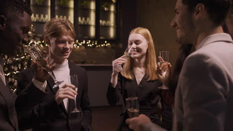 Group-Friends-Wearing-Stylish-Clothes-While-Talking-And-Toasting-With-Champagne-Glasses-At-New-Year's-Party-1
