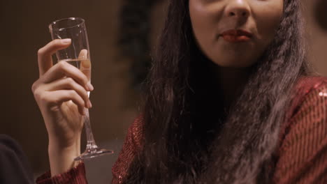 Close-Up-View-Of-A-Brunette-Girl-Wearing-Elegant-Clothes-While-Talking-With-Her-Friends-And-Holding-A-Glass-Of-Champagne-At-The-New-Year's-Party