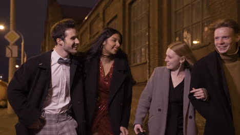 Two-Couples-Of-Friends-Dressed-In-Elegant-Clothes-Walking-In-The-Street-While-Talking-And-Laughing-After-New-Year's-Party
