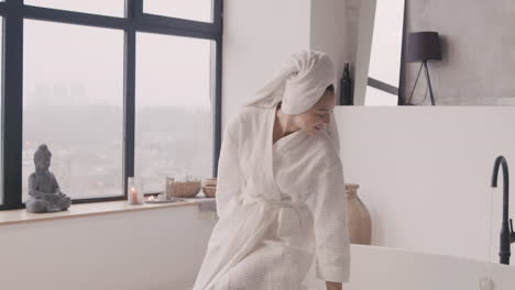 Woman-In-Bathrobe-Wraps-A-Towel-Around-Her-Head-To-Dry-Her-Hair