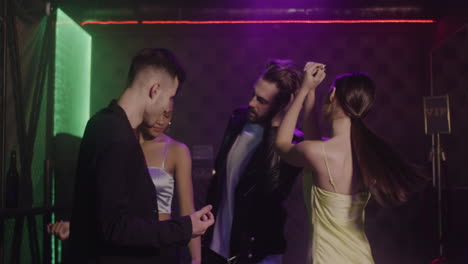 Group-Of-Four-Young-Friends-Dancing-At-Disco-1