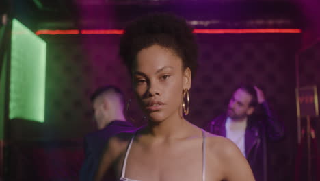 Portrait-Of-Beautiful-Girl-Looking-Confident-At-Camera-At-Disco-While-Her-Friends-Dancing-Behind-Her-1