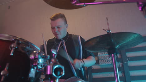 Young-Male-Musician-Playing-On-Drums-In-Recording-Studio