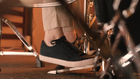 Close-Up-Of-An-Unrecognizable-Musician-Playing-Bass-Drum-And-Pressing-His-Foot-On-Pedal-During-A-Band-Rehearsal-In-Recording-Studio
