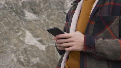 Close-Up-View-Of-Teenage-Boy-Hands-Using-Smartphone-On-The-Mountain