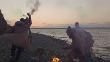 Group-Of-Teenage-Friends-Running-Around-A-Bonfire-Holding-Colored-Sparklers-On-The-Seashore-1