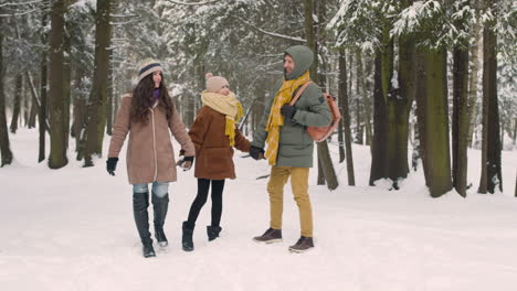 Vorderansicht-Von-Eltern-Und-Tochter-In-Winterkleidung-Im-Verschneiten-Wald