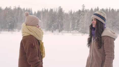 Front-View-Of-Mother-And-Daughter-In-Winter-Clothes-Approach-And-Hugging-In-A-Snowy-Forest