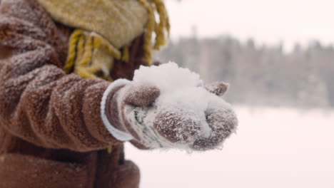 Nahaufnahme-Eines-Mädchens-In-Winterkleidung,-Das-Einen-Schneeball-Mit-Der-Hand-Hält