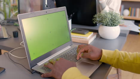 Nahaufnahme-Eines-Nicht-Erkennbaren-Mannes,-Der-Im-Büro-An-Einem-Modernen-Laptop-Mit-Grünem-Bildschirm-Arbeitet