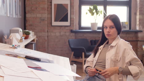 Beautiful-Woman-Smiling-At-Camera-While-Sitting-At-Drawing-Desk-In-An-Animation-Studio