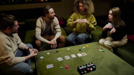 Blick-Von-Oben-Auf-Eine-Gruppe-Von-Freunden,-Die-Poker-Spielen-Und-Auf-Der-Couch-Im-Wohnzimmer-Sitzen