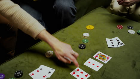Draufsicht-Auf-Die-Hände-Einer-Frau,-Die-Spielkarten-Und-Pokerchips-Auf-Den-Tisch-Nimmt