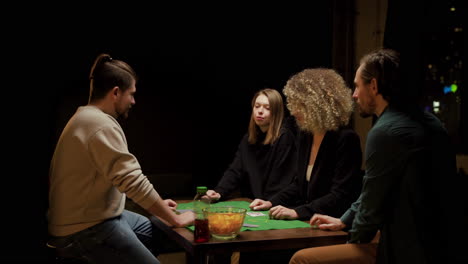 Gruppe-Von-Freunden,-Die-Poker-Spielen-Und-Zu-Hause-Auf-Stühlen-An-Einem-Tisch-Sitzen-2